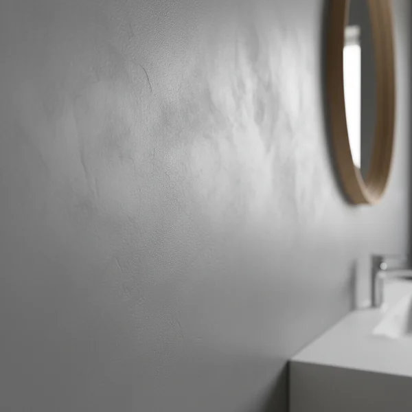 Professionell hantverkare applicerar mikrosement på badrumsvägg med stålspackel